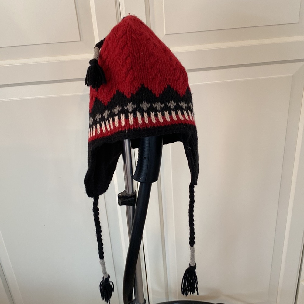 Red, black and white knit winter hat with earflaps